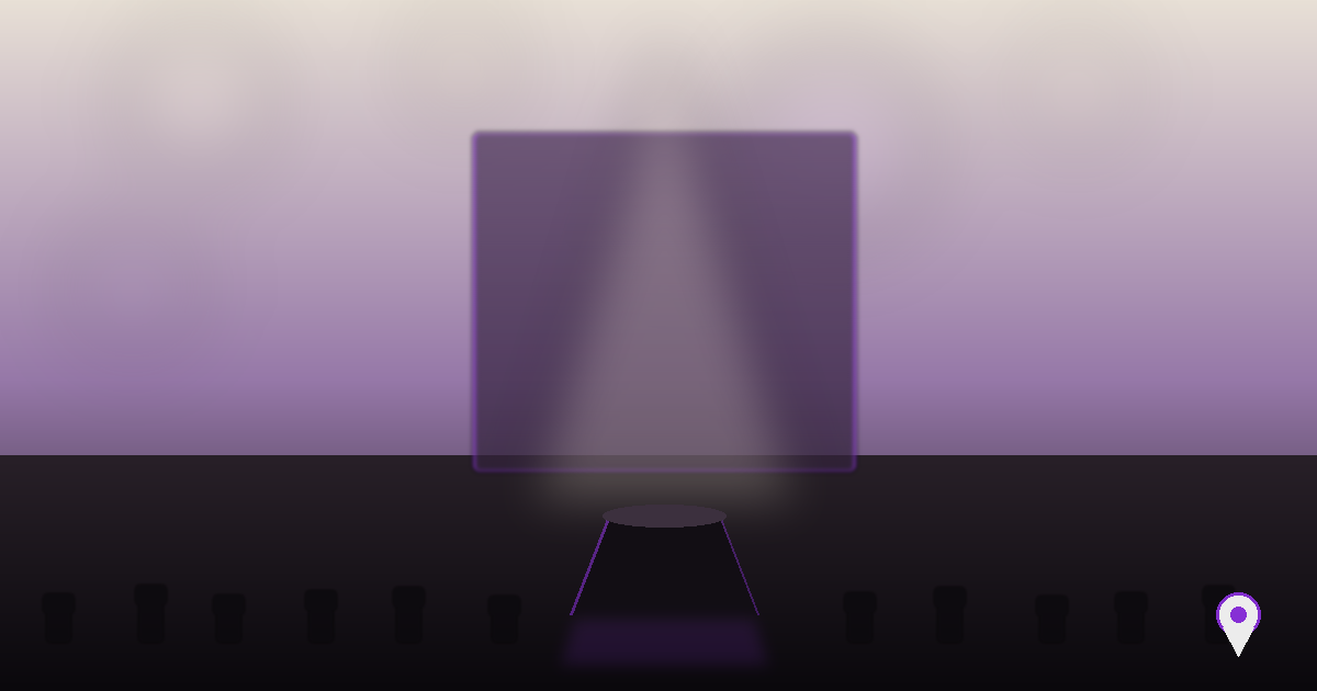 Palco de lançamento de produto com pedestal iluminado por spot, tela de fundo em tons violeta e fileiras de cadeiras ao redor, marcador de localização discreto no canto inferior direito